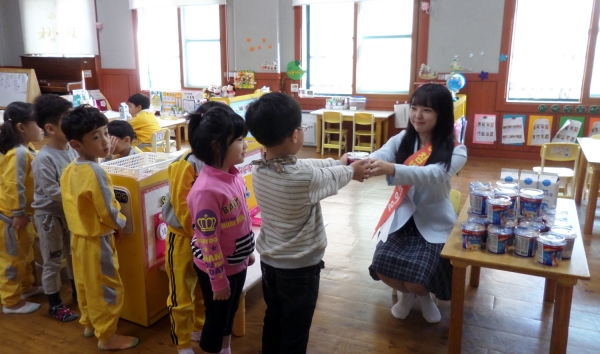 지난 13일 여수시어린이급식관리지원센터 관계자가 어린이집 아동들에게 시리얼과 우유를 나눠주고 있다.