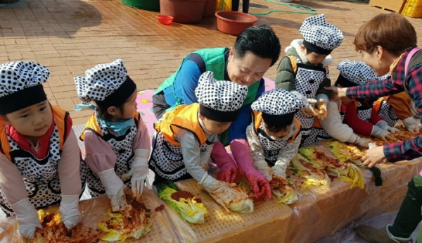 지난 28일 여수시 여천동 주민센터 광장에서 김지선 여천동장(가운데)이 어린이집 아동들과 어려운 이웃을 위한 김치를 담그고 있다.