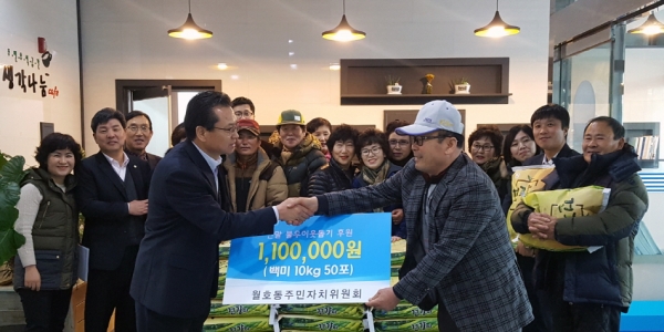 지난 22일 곽영수 여수시 월호동주민자치위원장(오른쪽)이 한광민 월호동장에게 110만 원 상당의 쌀 후원증서를 전달하고 있다.