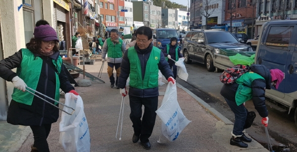 지난 8일 여수시 중앙동 새마을지도자들이 도로변에 방치된 쓰레기를 수거하고 있다.