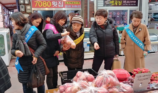 지난 8일 여수시 쌍봉동 통장들이 진남시장에서 전통시장 장보기 행사를 진행하며 직접 과일을 구입하고 있다.