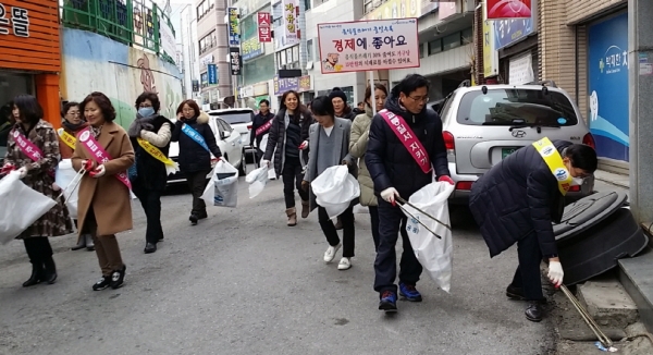 지난 9일 여서동 자생단체 회원들과 공무원들이 상가 주변에 방치된 쓰레기를 수거하고 있다.