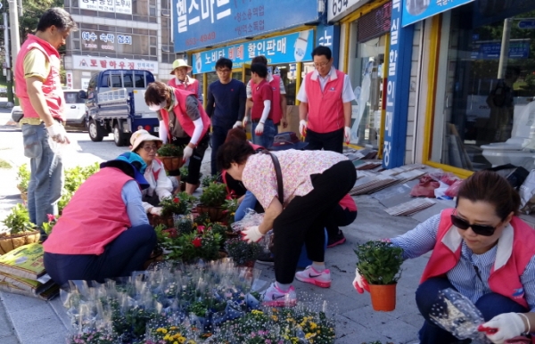 지난해 여수시의 도시재생 주민공모사업에 선정된 문수동 주민자치위원들이 상가주변에 꽃길을 조성하고 있다.