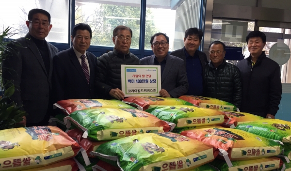 21일 코리아월드써비스㈜ 관계자들이 류갑선 미평동장(왼쪽 네 번째)에게 400만 원 상당의 쌀 후원증서를 전달하고 있다.