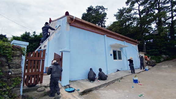 지난 26일 여수시 남면 송고마을로 봉사활동을 간 대한적십자사 여수지구협의회 관계자들이 주택 벽면을 새 페인트로 칠하고 있다.