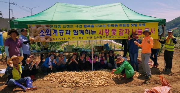지난 21일 여수시 만덕동 주민들이 사회복지시설 등에 전달하기 위해 직접 수확한 감자를 들어 보이고 있다.