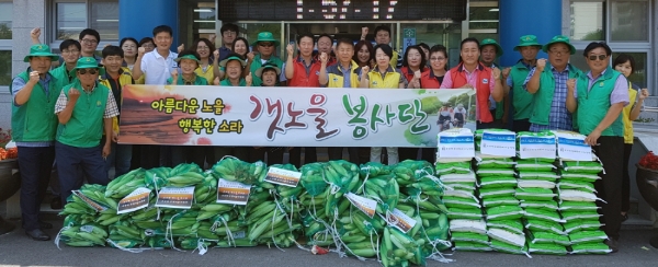 지난 18일 소라면 사회단체 회원들과 면사무소 공무원들이 수확한 옥수수 앞에서 기념사진을 찍고 있다.