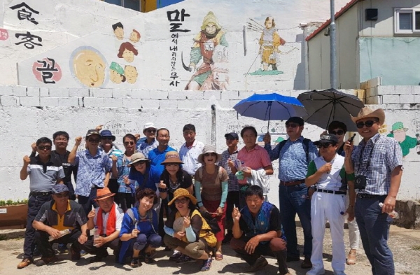 지난 13일 중앙동을 방문한 장성 동화면 주민자치위원들이 고소천사벽화마을에서 기념사진을 찍고 있다.