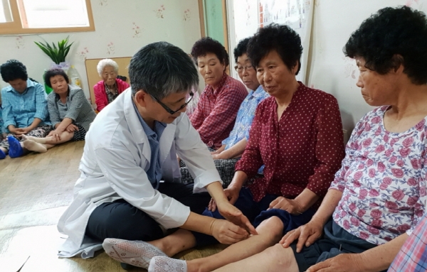 지난 1일 나경상 나한의원장이 여수 소라면 대포1리 경로당에서 다리가 불편한 어르신에게 침 치료를 하고 있다.