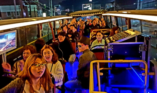 여수낭만버스 시간을 달리는 버스커 탑승객들이 여수야경을 감상하며 버스킹 공연을 즐기고 있다.